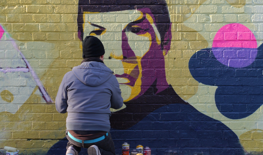 Graffiti artist painting an image of Dr. Spock on a wall, metaphorically representing innovative and creative approaches in ChatGPT training
