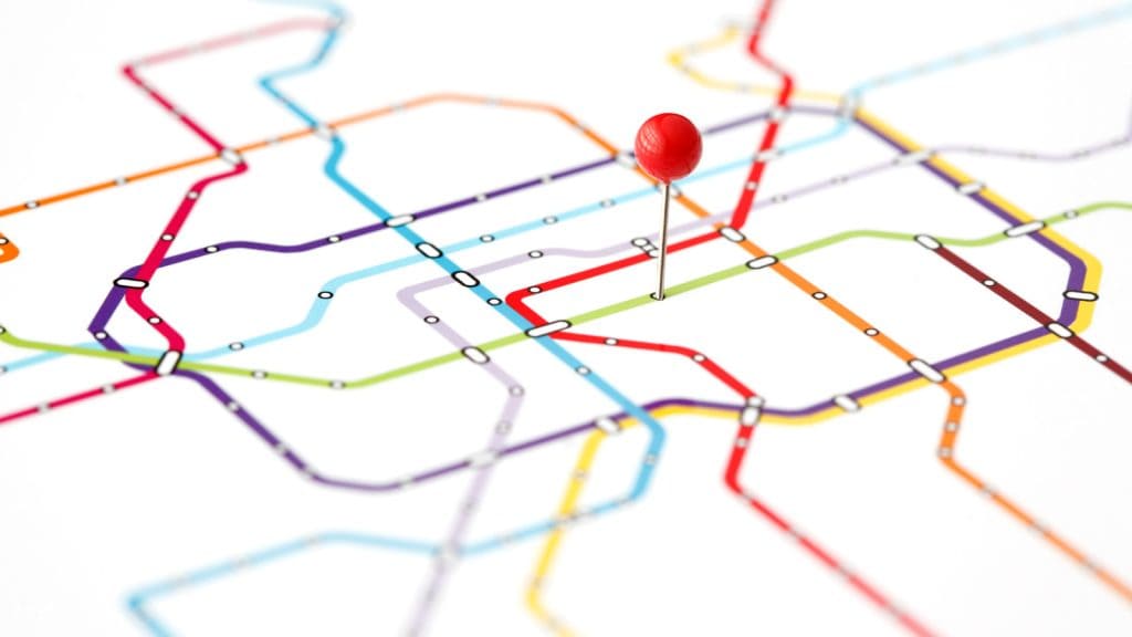 Abstract subway map with colourful journey lines and a red pin symbolising customer journey stages and mapping.