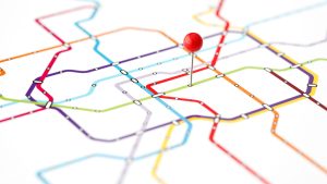Abstract subway map with colourful journey lines and a red pin symbolising customer journey stages and mapping.