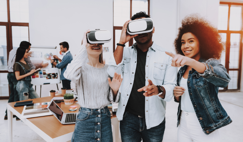 Two people wearing VR glasses stare where a third person points