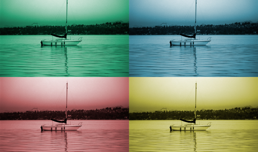 Four quadrants of a sailboat on calm waters, each tinted in a different color, signifying the multifaceted roles and environments in project management.
