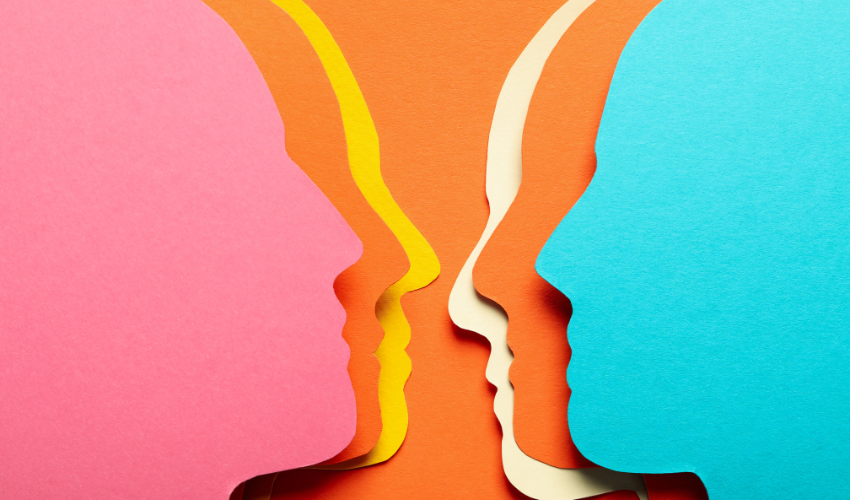 Colorful paper cutouts of human heads in profile, layered in a row on an orange background, symbolizing diverse perspectives and communication in project management.